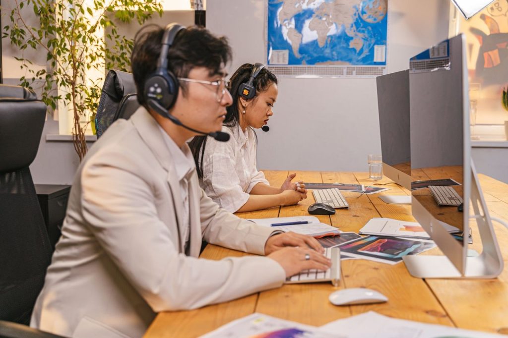 Decreto atualiza atendimento do SAC e reforça direitos dos consumidores Agentes de atendimento trabalham em computadores usando headsets em um escritório moderno.
