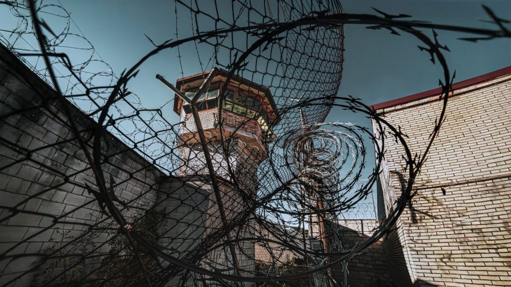 Decreto institui programa nacional para bloquear comunicações ilegais em presídios Torre de vigilância de um presídio vista por trás de arame farpado.
